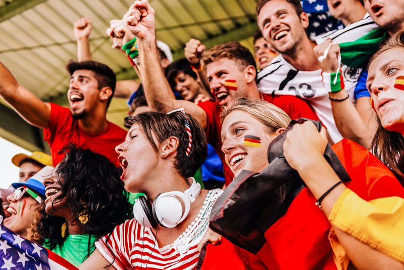 personas en unas gradas viendo un juego y celebrando